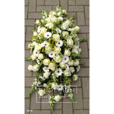 Wit rouwarrangement rijkelijk gevuld in langwerpige vorm van witte bloemen